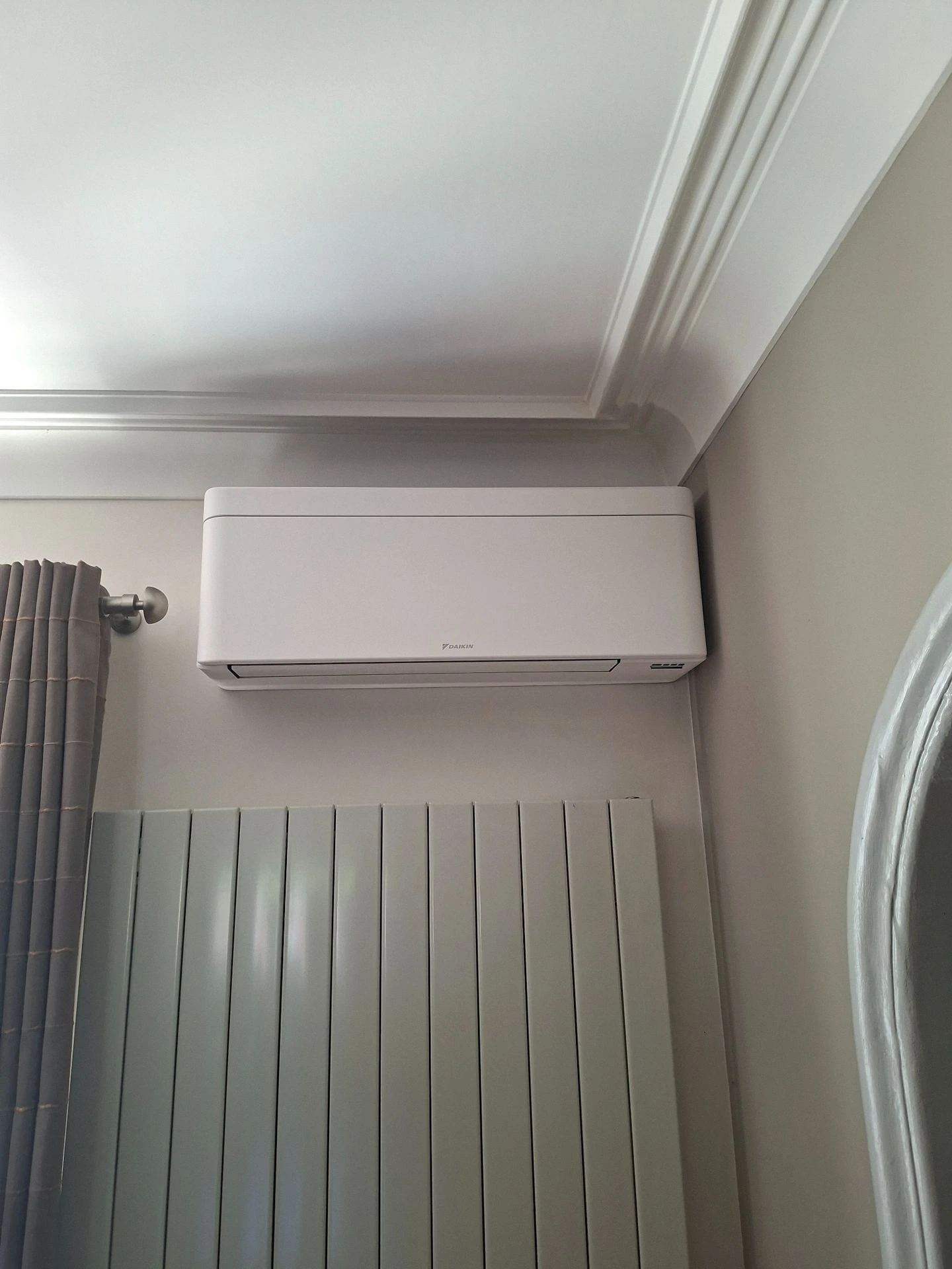 Climatiseur mural au-dessus d’un radiateur